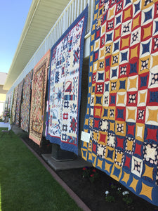 Quilts hanging from a balcony at the quilt show.